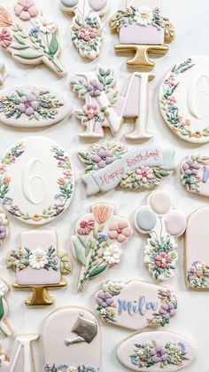 some decorated cookies are laying out on a white table top with the words happy birthday written in large letters