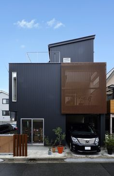 a car is parked in front of a black building with wooden slats on it