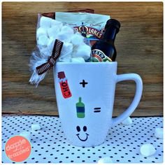 a coffee mug filled with candy, marshmallows and a bottle of beer