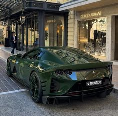 a green sports car parked in front of a building