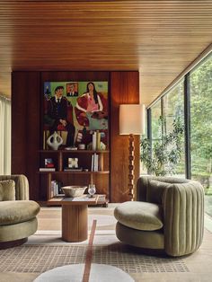 a living room with two chairs and a table in front of a large glass window