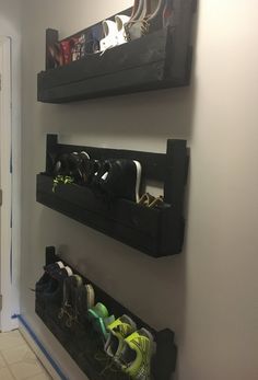 there are two black shelves with shoes in them on the wall next to each other