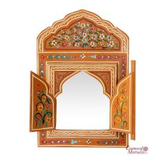 an intricately decorated mirror is shown against a white background with flowers and leaves on it