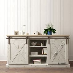 an entertainment center with sliding doors and a potted plant on top