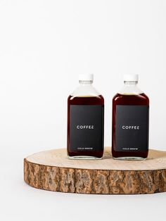 two bottles of coffee sitting on top of a wooden table