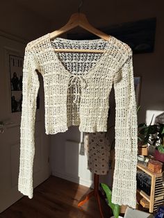 a white sweater hanging on a wooden hanger