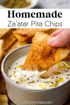 a hand dipping a tortilla chip into a bowl of homemade za'atar pita chips