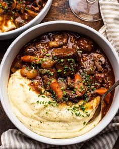 two bowls filled with mashed potatoes and beef stew