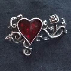 Alchemy Gothic England R180 Bed of Blood Roses Ring A bed of tangled emotions and romance; sparkling roses flourish within the heart's blood of this finger-spanning ring. Swarovski crystals glitter from beneath the bright red enamel Hallmarked with size / brand logo / Year 2012 Discontinued ring. Set with red resin heart. Original packaging available  GUARANTEED to be an authentic item.  About Alchemy England All of Alchemy England's pewter products are individually designed, modelled and developed in England by the Alchemy studios creative art and design team. Each individual product is then hand-made with pride from the finest English pewter by alchemy's highly skilled craftsmen in their workshops in England. Roses Ring, Alchemy Gothic, Art And Design, Alchemy, Bright Red, Rings Statement, Handmade Ring, Ring Set, Creative Art