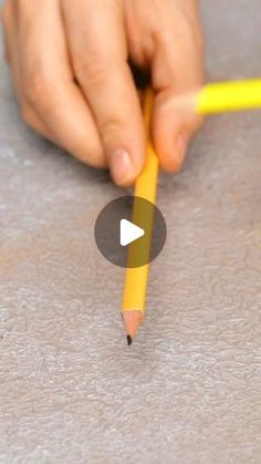 a person holding a pencil in their hand