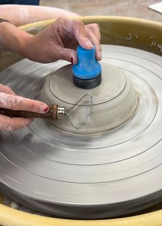 a person is spinning something on a wheel with a blue object in it's center