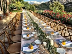 a long table is set with place settings for an outdoor dining event in the mountains