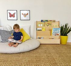 a little boy sitting on a bean bag chair reading a book