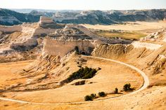 an aerial view of the badlands and hills in the desert, with trees on each side