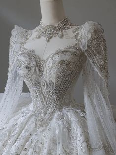 a white wedding dress with long sleeves and beading