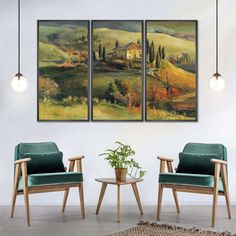 two chairs and a table in a room with paintings on the wall