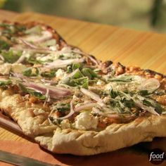 a pizza sitting on top of a wooden cutting board