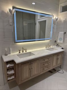 a bathroom with two sinks and a large mirror over it's counter top area