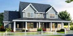 a two story house with lots of windows and flowers in the front yard, on a cloudy day