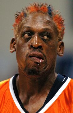 a close up of a person wearing an orange and white shirt with mohawks on his head