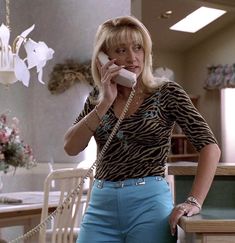 a woman talking on a phone while standing next to a table