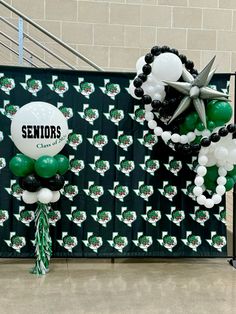 some balloons are hanging on a wall with the words seniors above them and an arrow