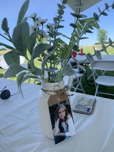 a vase filled with flowers sitting on top of a white table cloth covered tablecloth