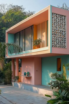 a pink and blue house with palm trees in the background