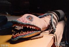 a stuffed toy shark laying on top of a wooden table