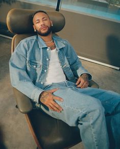 a man sitting in a chair with his legs crossed