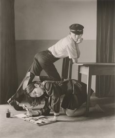 an old black and white photo of two people on the floor with one woman leaning over another