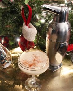 a drink sitting on top of a table next to a christmas tree