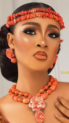 a woman wearing an orange necklace and matching earrings