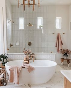 a white bath tub sitting in a bathroom next to a window