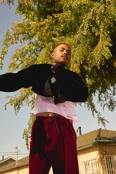 a man standing under a tree with his arms outstretched