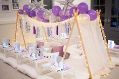 purple and white balloons are hanging from the ceiling