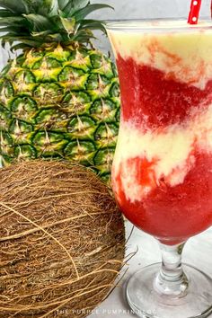 a drink in a glass next to a pineapple