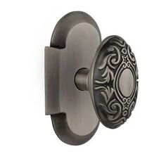 an antique style door knob with decorative design on it's face and the handle is shown