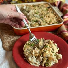 a red plate topped with food next to a casserole dish filled with stuffing