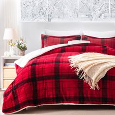 a red and black plaid comforter set on a bed