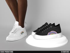 a pair of black and white shoes with rainbows on them, standing next to each other