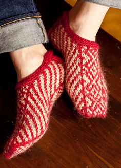 a person wearing red and white knitted slippers