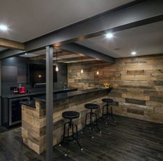 an open concept kitchen with wood paneling and bar stools in the center area