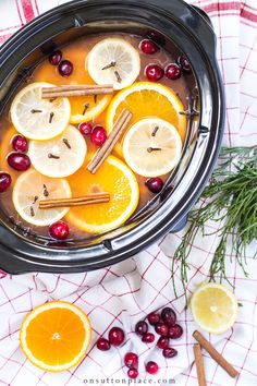 cranberry orange cider punch recipe with cinnamon sticks and lemons in it