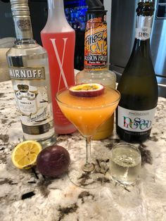 an assortment of alcoholic drinks sitting on a counter top next to bottles and glassware