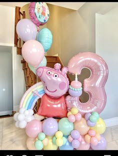 a birthday party with balloons and decorations including a peppa the pig number 3 balloon centerpiece