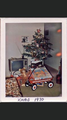 an old photo of a living room with a christmas tree in the corner and toys on the floor