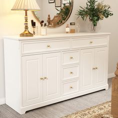 a white dresser topped with lots of drawers and a mirror on it's side