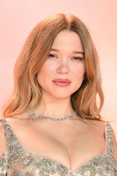 a close up of a person wearing a necklace and dress with diamonds on the neck