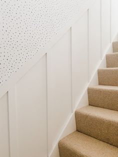 a set of stairs leading up to a wall with polka dots on the walls and carpet